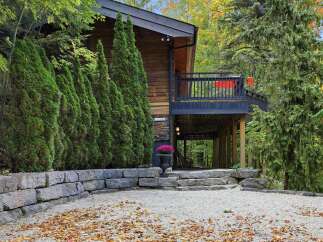 Experience the charm of this rustic wooden home nestled amidst lush greenery and mature trees.