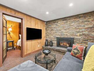 Cozy up by the stone fireplace in this inviting living area, perfect for relaxing evenings.