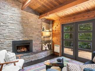 Cozy living room featuring a stunning floor-to-ceiling stacked stone fireplace, perfect for gathering on cool evenings.