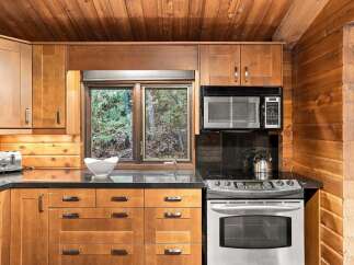 Experience rustic charm in this cozy kitchen, featuring warm wood cabinetry and a beautiful wooden ceiling.