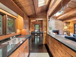 Experience rustic charm in this open-concept living space featuring a well-appointed kitchen with granite countertops and ample wood cabinetry.