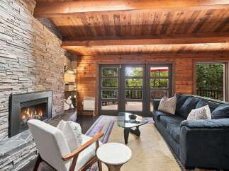 Experience cozy living in this inviting living room, featuring a stunning stacked stone fireplace that serves as the focal point.