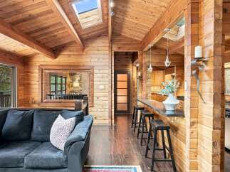 Experience rustic charm in this beautifully appointed living space, featuring a vaulted wood-paneled ceiling with skylights that flood the area with natural light.