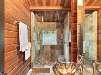 Experience rustic luxury in this stunning bathroom featuring warm wood paneling throughout.