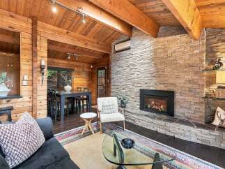 Experience rustic charm in this inviting living space, featuring a stunning floor-to-ceiling stone fireplace as the focal point.
