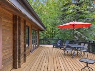 Enjoy the outdoors on this expansive wooden deck, perfect for entertaining or relaxing amidst nature.