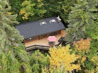 Nestled amidst vibrant autumn foliage, this charming wooden cabin offers a serene retreat.