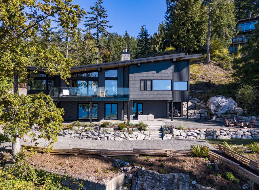 Experience modern luxury with this stunning waterfront home, featuring expansive windows that capture breathtaking ocean views.
