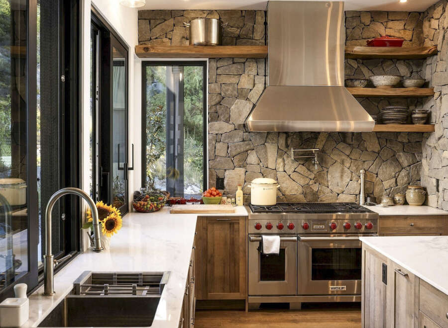 Experience rustic elegance in this stunning kitchen, featuring a striking stone accent wall that adds warmth and texture.