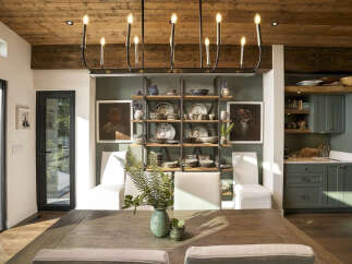 Experience rustic charm and modern elegance in this dining area, featuring a warm wooden ceiling and exposed beams.