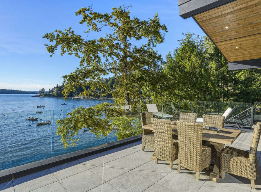 Enjoy breathtaking waterfront views from this stunning modern home's expansive patio.