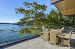 Enjoy breathtaking waterfront views from this stunning modern home's expansive patio.
