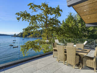 Enjoy breathtaking waterfront views from this stunning modern home's expansive patio.