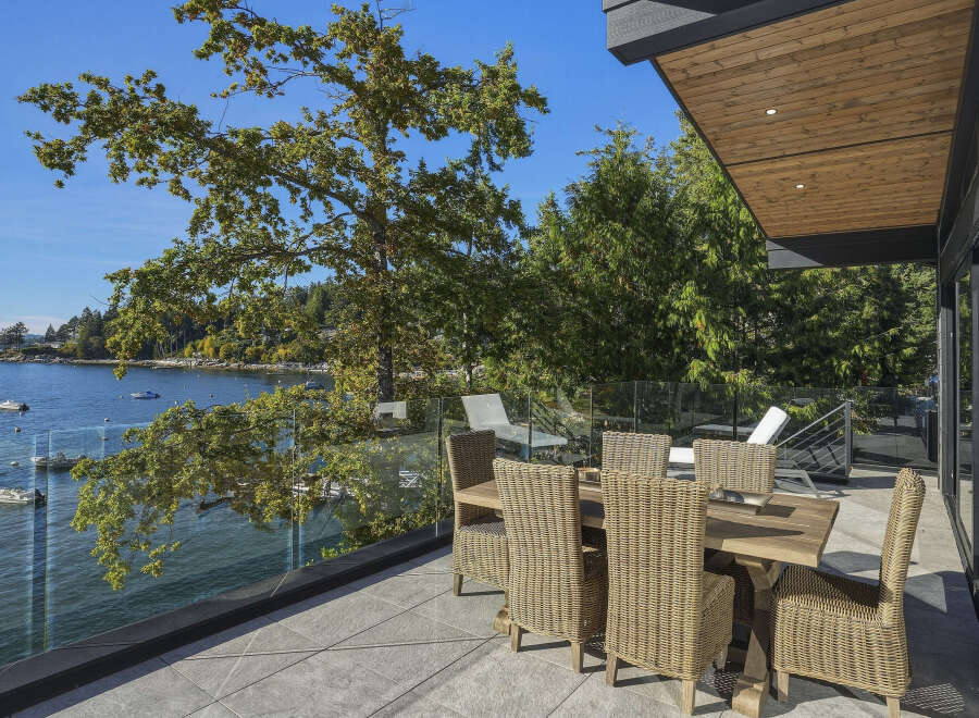 Enjoy breathtaking waterfront views from this stunning modern home's expansive deck.