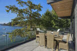 Enjoy breathtaking waterfront views from this stunning modern home's expansive deck.