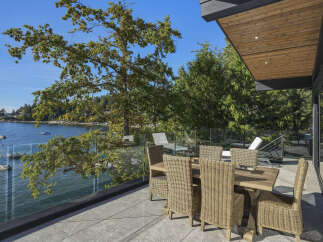 Enjoy breathtaking waterfront views from this stunning modern home's expansive deck.