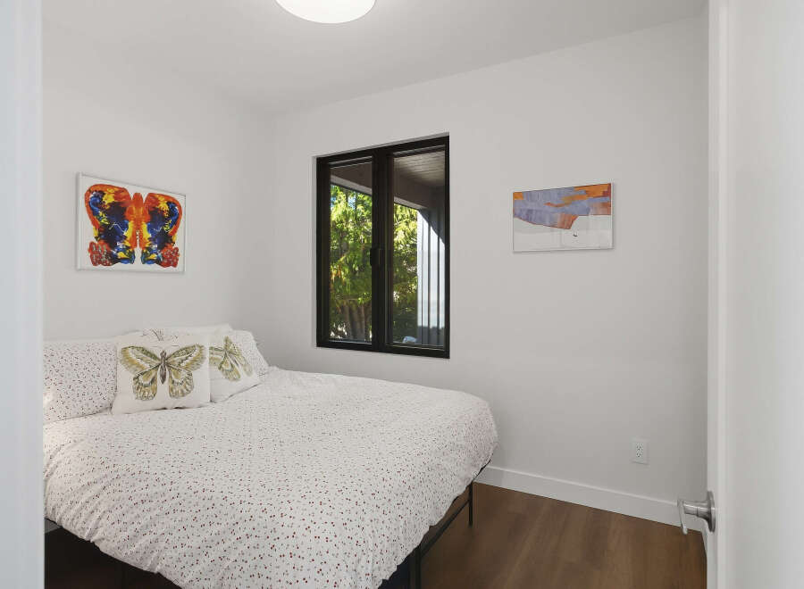 This bedroom features a comfortable bed adorned with butterfly-themed pillows and a white duvet with a subtle pattern.