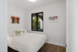 This bedroom features a comfortable bed adorned with butterfly-themed pillows and a white duvet with a subtle pattern.
