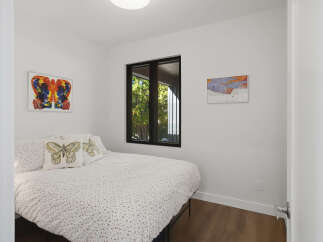 This bedroom features a comfortable bed adorned with butterfly-themed pillows and a white duvet with a subtle pattern.