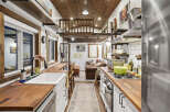 Experience cozy living in this charming tiny home, featuring a well-equipped kitchen with butcher block countertops and a gas range, perfect for culinary adventures.