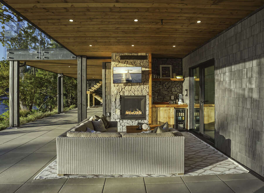 Experience luxurious outdoor living with this stunning covered patio, featuring a cozy fireplace and a fully equipped bar area.