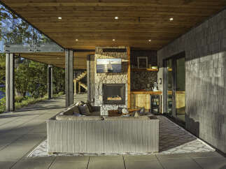 Experience luxurious outdoor living with this stunning covered patio, featuring a cozy fireplace and a fully equipped bar area.