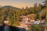 Experience luxury waterfront living in this stunning modern home nestled amidst a lush forest setting.