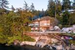 Experience luxury living in this stunning modern home nestled amidst lush trees and rocky shores.