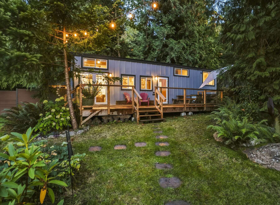 Experience the charm of this modern tiny home nestled amidst lush greenery.