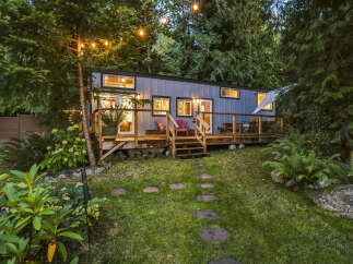 Experience the charm of this modern tiny home nestled amidst lush greenery.