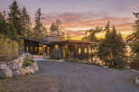 Experience modern luxury in this stunning home, featuring a striking dark exterior and a unique asymmetrical roofline.