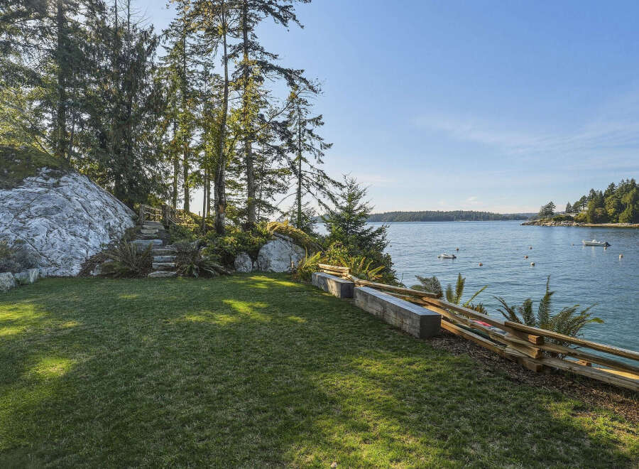 Enjoy breathtaking ocean views from this stunning property, featuring a lush green lawn perfect for outdoor relaxation.
