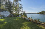 Enjoy breathtaking ocean views from this stunning property, featuring a lush green lawn perfect for outdoor relaxation.