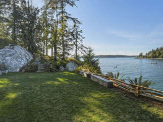 Enjoy breathtaking ocean views from this stunning property, featuring a lush green lawn perfect for outdoor relaxation.