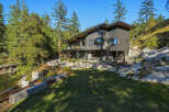 Discover this stunning modern home nestled amidst lush greenery and rocky terrain, offering breathtaking water views.