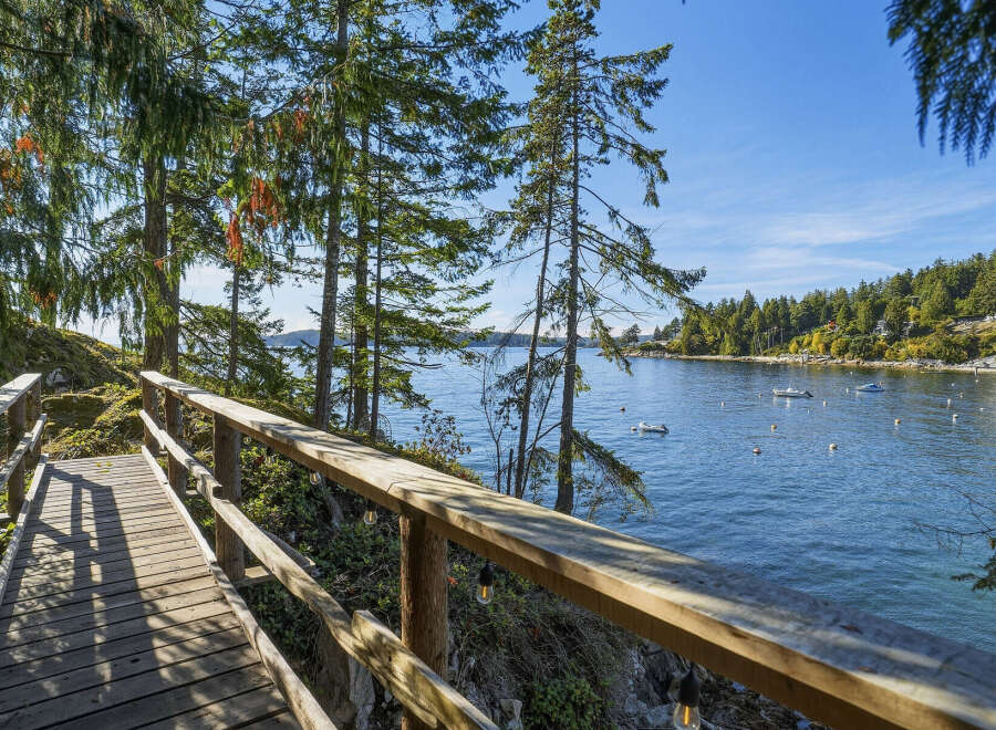 Enjoy breathtaking waterfront views from this charming property, featuring a scenic wooden boardwalk leading to the serene waters.
