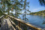 Enjoy breathtaking waterfront views from this charming property, featuring a scenic wooden boardwalk leading to the serene waters.