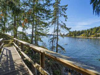 Enjoy breathtaking waterfront views from this charming property, featuring a scenic wooden boardwalk leading to the serene waters.