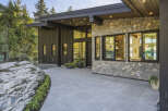Experience modern luxury in this stunning home featuring a striking stone facade and sleek vertical siding.