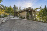 This modern home boasts a unique architectural design with a mix of vertical metal siding and natural stone accents.