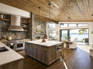Experience luxury living in this stunning kitchen and dining area, boasting a large stone fireplace and breathtaking ocean views.
