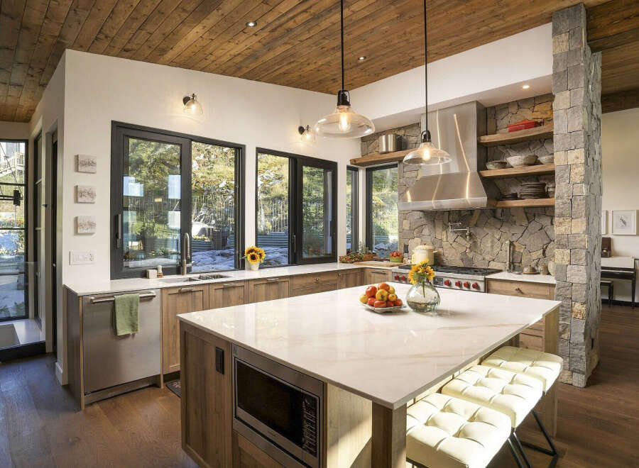 Experience luxury mountain living in this stunning kitchen, featuring a spacious island with a quartz countertop and integrated microwave.