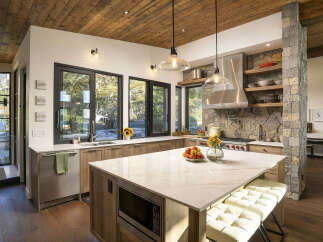 Experience luxury mountain living in this stunning kitchen, featuring a spacious island with a quartz countertop and integrated microwave.
