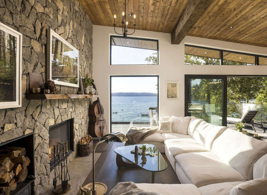 Experience breathtaking waterfront living in this stunning modern home, featuring a dramatic stone fireplace and expansive windows that frame panoramic ocean views.