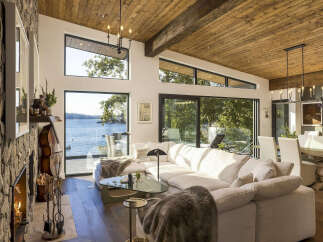 Experience breathtaking waterfront living in this stunning modern home, featuring expansive windows that flood the space with natural light and offer panoramic views of the serene lake.