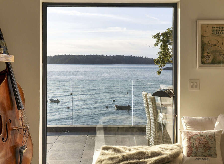 Experience breathtaking waterfront living with this stunning property, featuring expansive windows that frame panoramic ocean views.