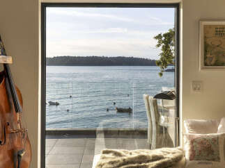 Experience breathtaking waterfront living with this stunning property, featuring expansive windows that frame panoramic ocean views.