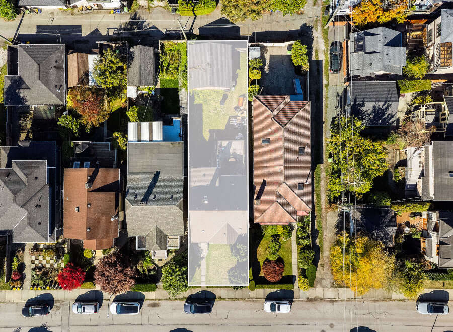 Discover this charming property from an aerial perspective, showcasing a well-maintained roof and a spacious backyard perfect for outdoor activities.
