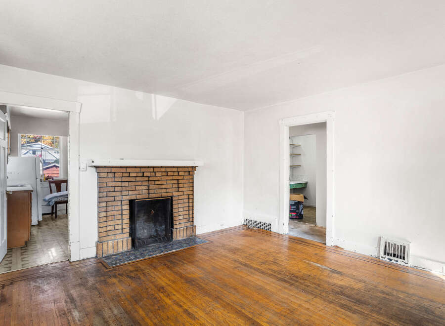 Step into this charming living space featuring a classic brick fireplace, perfect for cozy evenings.