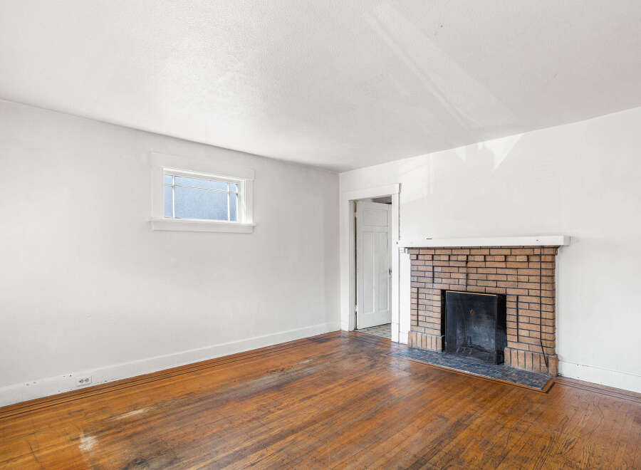 This charming living room features a classic brick fireplace, perfect for cozy evenings.